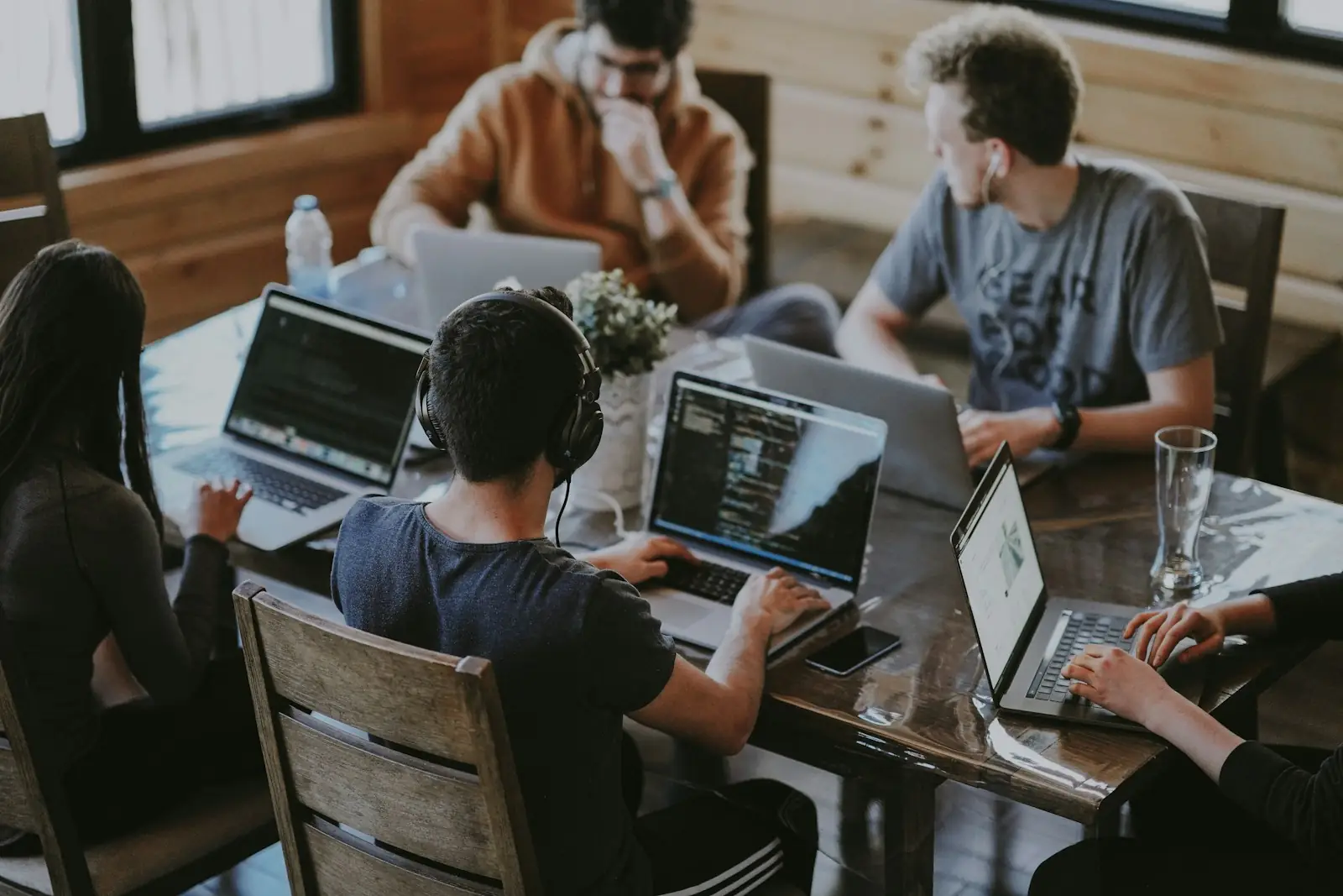 Developers and marketers working on laptops around a shared table